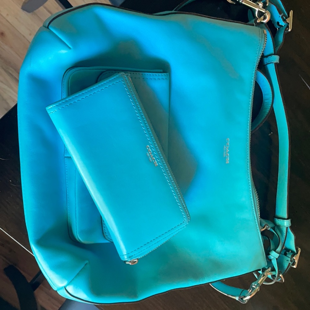 A vibrant turquoise coach handbag/wallet